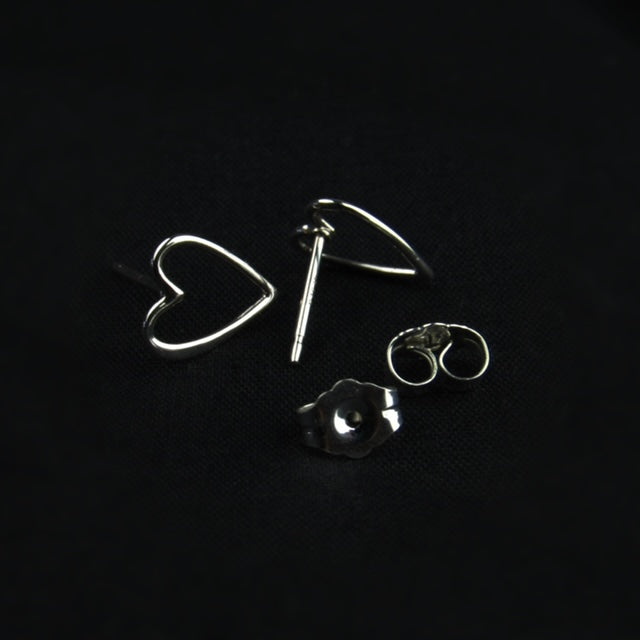 Silver heart-shaped earrings on a black background