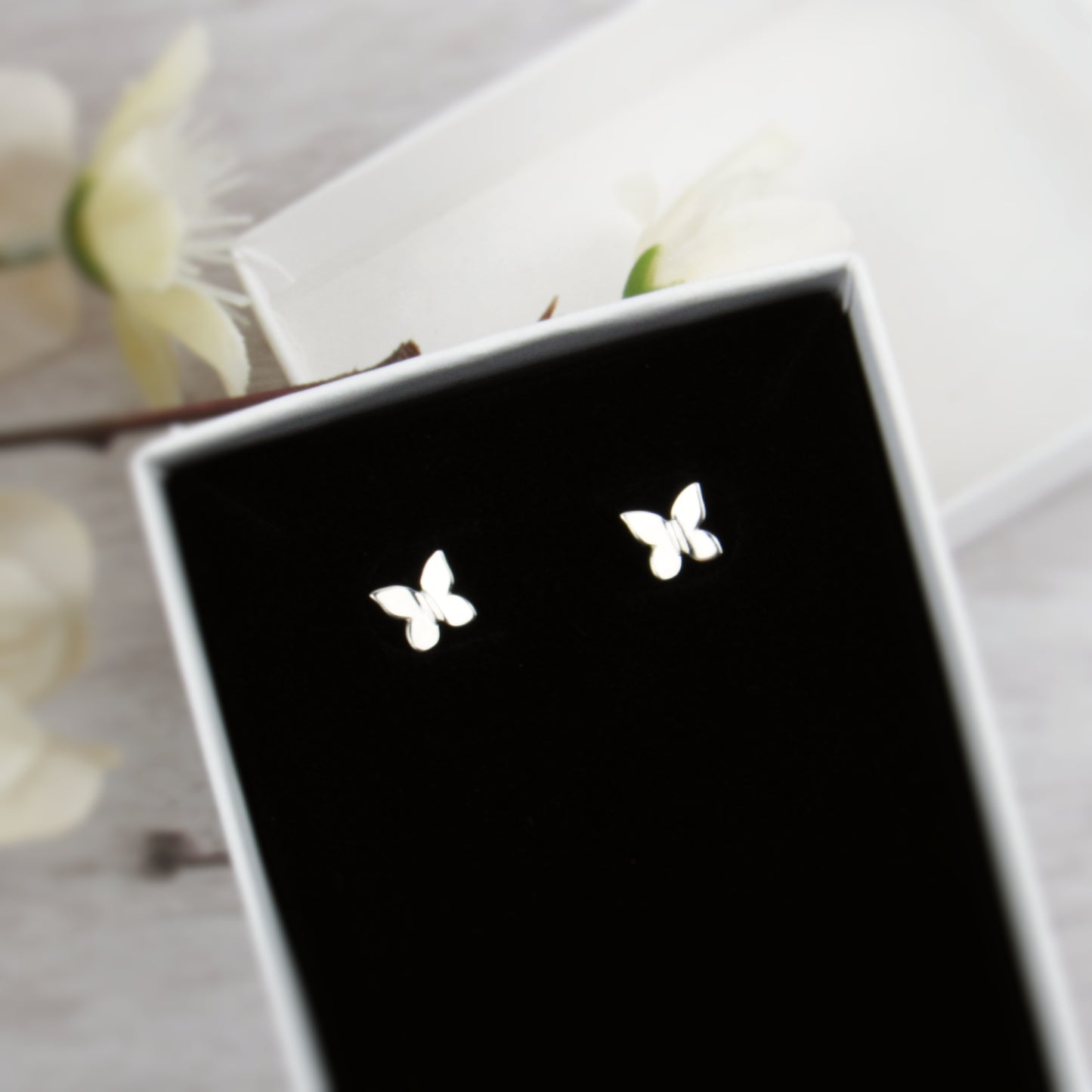Butterfly earrings on a black display card