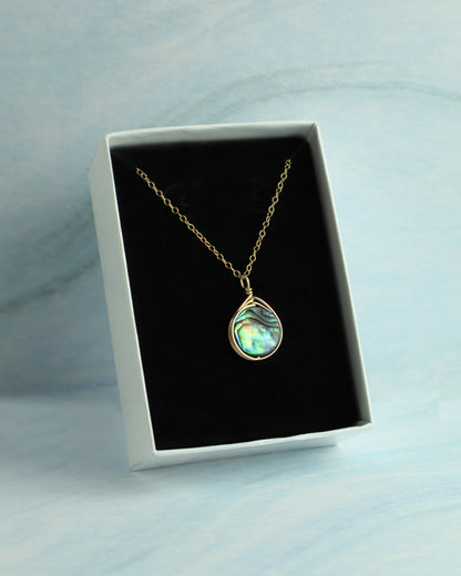 Necklace with a pendant in a white box on a light blue background