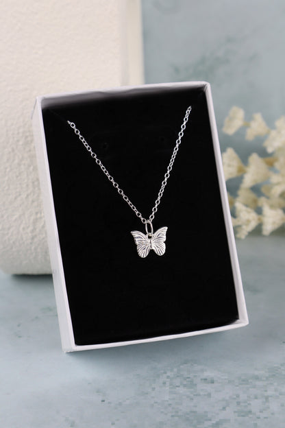 butterfly pendant necklace on a black insert in a white box