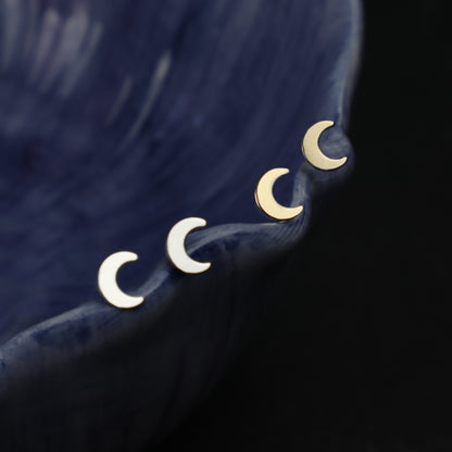 moon earrings resting on a blue bowl