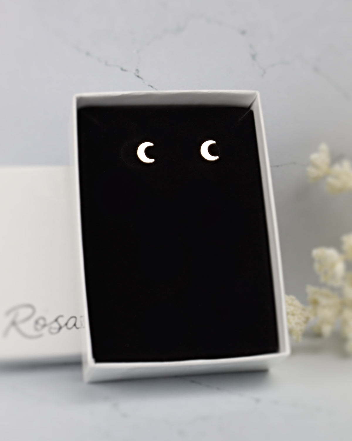 silver moon earrings in a black and white jewelry box