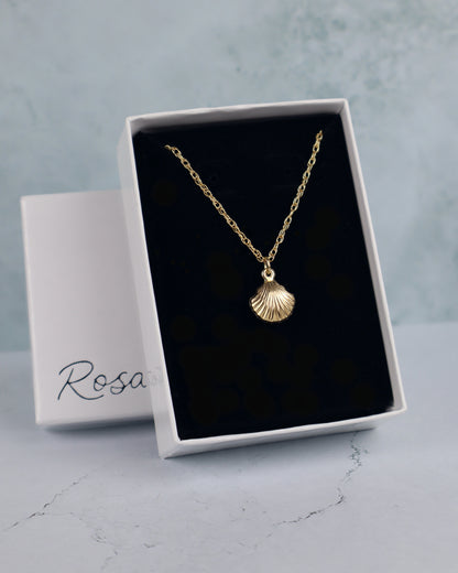Gold necklace with a shell pendant in a white box labeled 'Rosa'.
