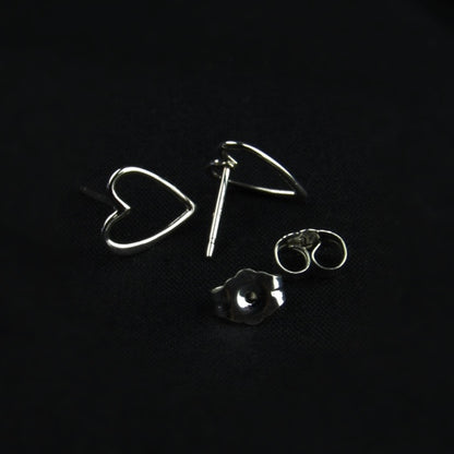 Silver heart-shaped earrings on a black background