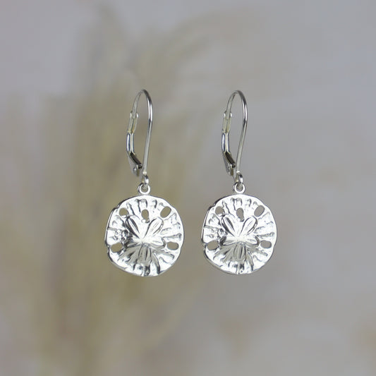 Pair of silver sterling sand dollars earrings on a blurred background